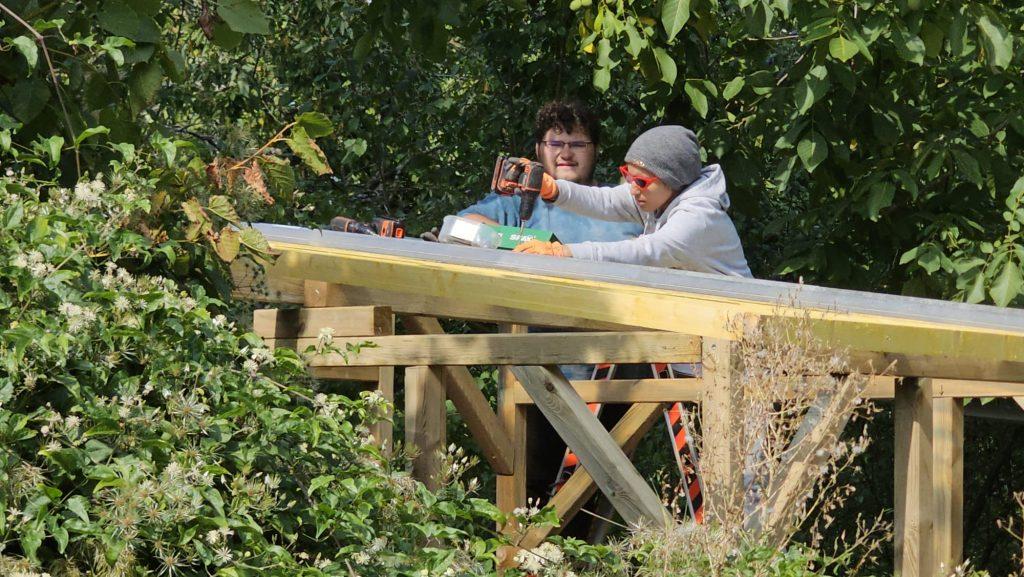Assma qui est en train de construire une cabane avec d'autres jeunes de la Mission Locale.